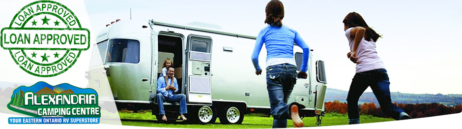 Children running toward their father who's sitting in the doorway of an RV