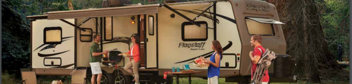 A family preparing a meal outside of their RV in the woods